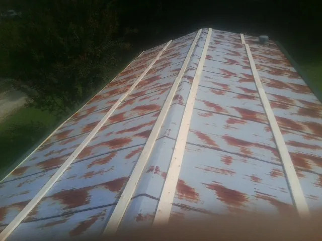 Rusted metal roof panels with new wood purlins before replacement — Storm Damage Roof Repair in Casselton by Roofing Brothers